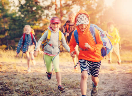 Group of the children with backpacks on the nature near the sea.の写真素材