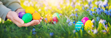 Human hands holding colourful vivid easter eggs