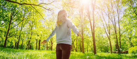Woman standing in the spring natural park with wide openning hands.の写真素材