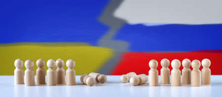 Abstract photography with figurines of wooden men on the background of colours of the Russian and...