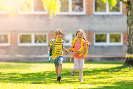 Boy and girl running to the schoolの写真素材