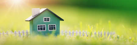 Green house model with fence standing on the green grassの写真素材