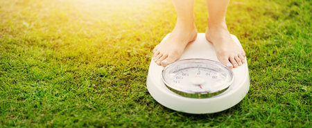 Woman standing on the white scales with bare feet in nature.の写真素材