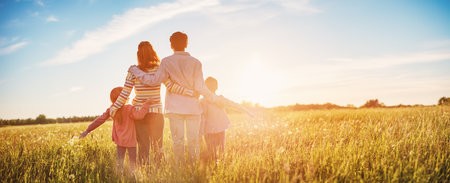 Happy family in the nature together on the evening sunsetの写真素材