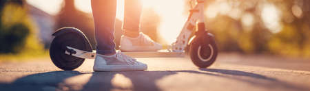 Woman riding on scooter on asphalt road in summer