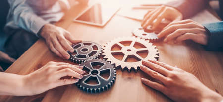 Group of people working in the office while putting together cogwheels.の写真素材