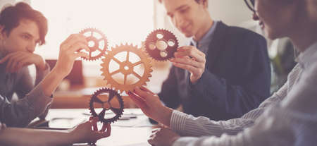 Group of people working in the office while putting together cogwheels.の写真素材