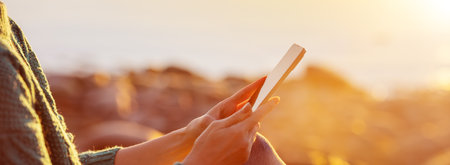 Woman outdoors relaxing with smartphone in her hands.