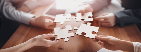 Buisnesswomen and buisnessmen working together while putting together puzzles.の写真素材