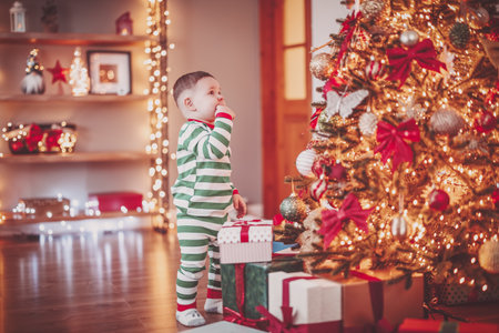 Little boy in pajama standing near the Christmas tree.の写真素材