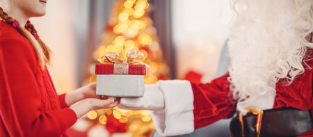 Hands of Santa Claus giving giftbox to the child.の写真素材
