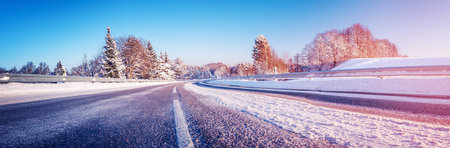 Panoramic view of the wide snowy road in winterの写真素材