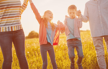 Happy family walking on the field on summertime.の写真素材