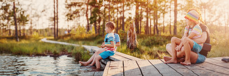 Mother with her children sitting on the pier of the swamp lake.の写真素材