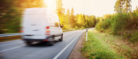 Van moving on the country road in natural park on the sunset.の写真素材