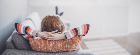 Tired woman lying down on the couch after workday.の写真素材