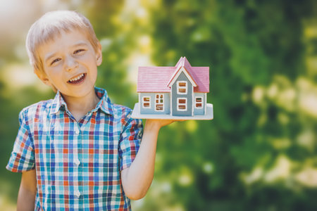 Little child holding in his hand a model of the house.の写真素材