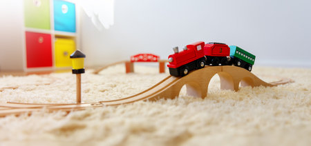 Closeup view of the toy train on the wooden bridge on the floor indoors.の写真素材