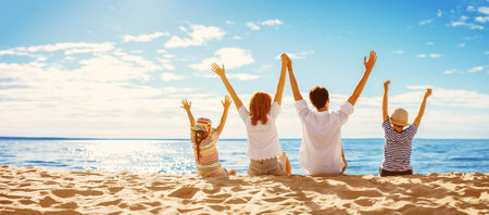 Parents with their child sitting in the sand on the seashore in sunny day.の写真素材