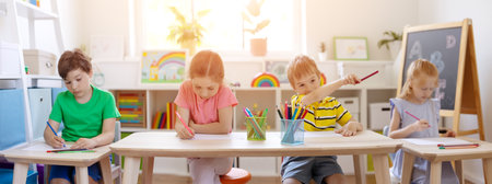 Group of children sitting in the classroom and drawing.の写真素材