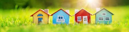 Four colourful models of houses standing on the lawn in natural park.の写真素材