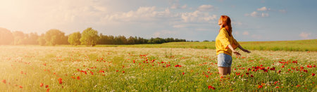 Woman in profile standing on the field with a lot of wild flowersの写真素材