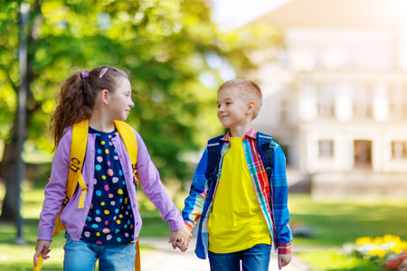 Girl and boy going from school by holding hands.の写真素材