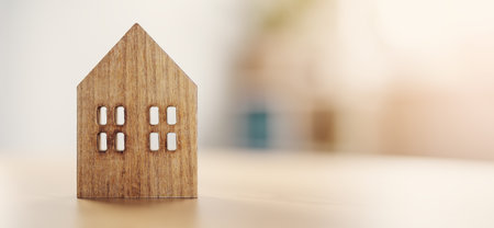 Figurine of wooden house standing on the table indoors.の写真素材