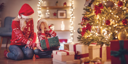 Mother giving Christmas gift box to her cute son.の写真素材