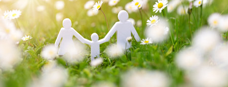 Figurines of family standing on the fields with white daisies.の写真素材
