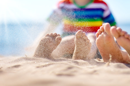 Happy children sitting on the sand beach in sunny day.の写真素材