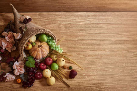 Thanksgiving cornucopia fill in fruit isolated wooden background in autumn and fall harvest seasonの写真素材