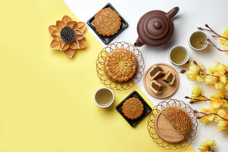 Mid autumn Festival. Chinese traditional moon cake and tea isolated on yellow and white backgroundの写真素材