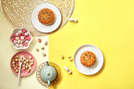 Flat lay Mid autumn festival moon cake, lotus seed and tea on yellowの写真素材