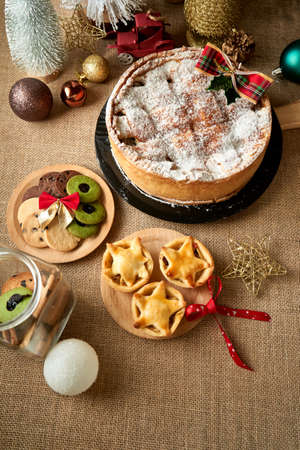 Christmas cake and cookies on rustic background