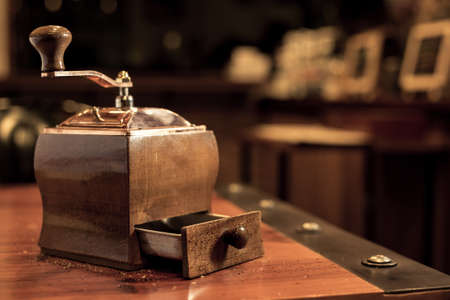 Coffee grinder. coffee maker by manual hand grinder on wood table in coffee shop.の写真素材