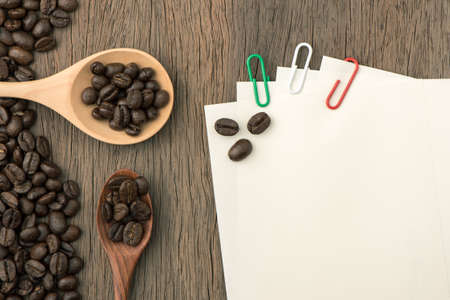 Coffee beans and paper note on wood table.Colour clip.の写真素材