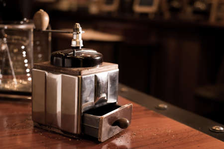 Coffee grinder. coffee maker by manual hand grinder on wood table in coffee shopの写真素材