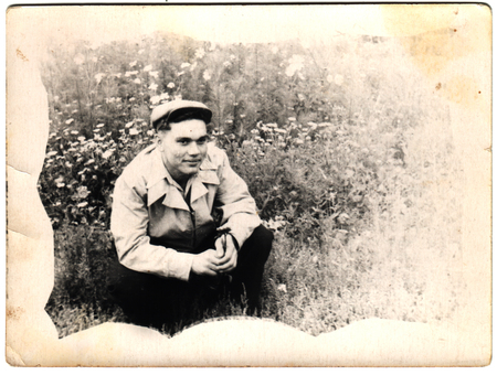 USSR  - CIRCA 1965s: An antique photo shows Man sitting in a fieldのeditorial素材