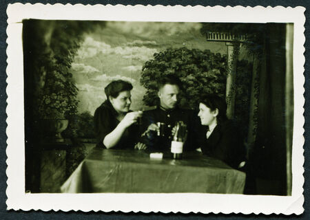 USSR - CIRCA 1950s: An antique photo shows Studio portrait of a family sitting at a table drinking alcoholのeditorial素材