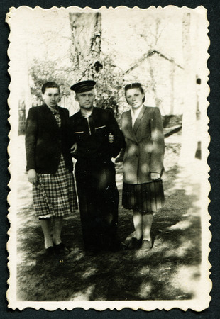 USSR - CIRCA 1950s: An antique photo shows sailor and two young women, USSR, circa 1950s