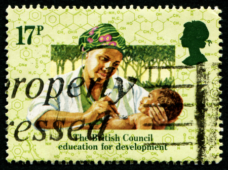 UNITED KINGDOM - CIRCA 1984: A stamp printed in United Kingdom issued for the 50th anniversary of British Council education for development shows nurse with child, circa 1984のeditorial素材