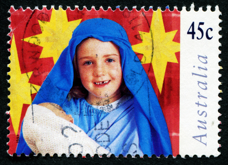 AUSTRALIA - CIRCA 1997: A stamp printed in Australia shows girl with a doll in his hand depicts the Holy Virgin, circa 1997のeditorial素材