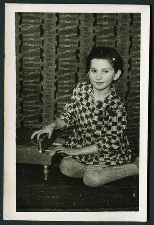 USSR - CIRCA 1970s: An antique photo shows little girl sitting in a toy piano, USSR, circa 1970sのeditorial素材