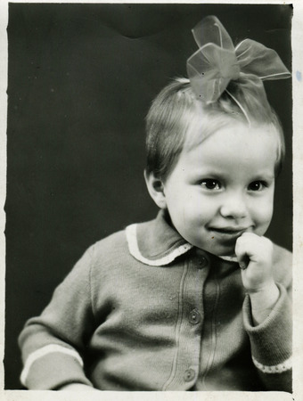 USSR - CIRCA 1980s: An antique photo show little girl with a bow on her headのeditorial素材