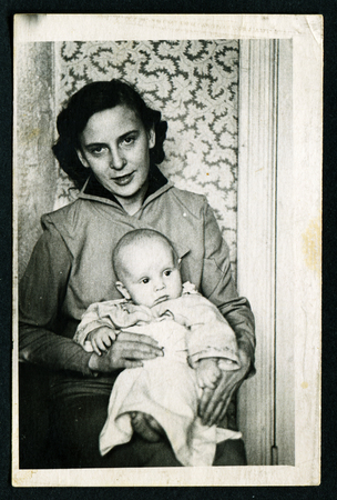 Petropavlovsk , USSR - CIRCA 1980: An antique photo shows portrait of a young mother and newborn baby boy in her arms.のeditorial素材