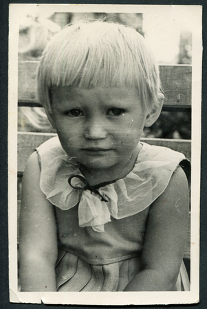 USSR - CIRCA 1952: An antique photo shows little offended girl sitting on the benchのeditorial素材