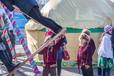 PETROPAVLOVSK, KAZAKHSTAN - MARCH 21, 2015: celebration of the new year on the solar calendar astronomical in Iranian and Turkic peoples. children swingのeditorial素材