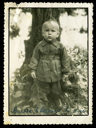 Ussr - CIRCA 1980s: An antique Black & White photo show little boy dressed as a soldier. Caption for photo: "Volodya aged 1 year 5 months"のeditorial素材