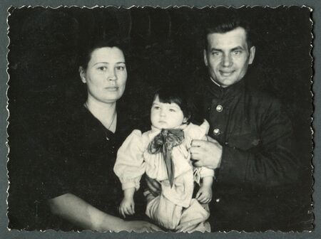 Ussr - CIRCA 1970s: An antique Black & White photo show parents with daughterのeditorial素材
